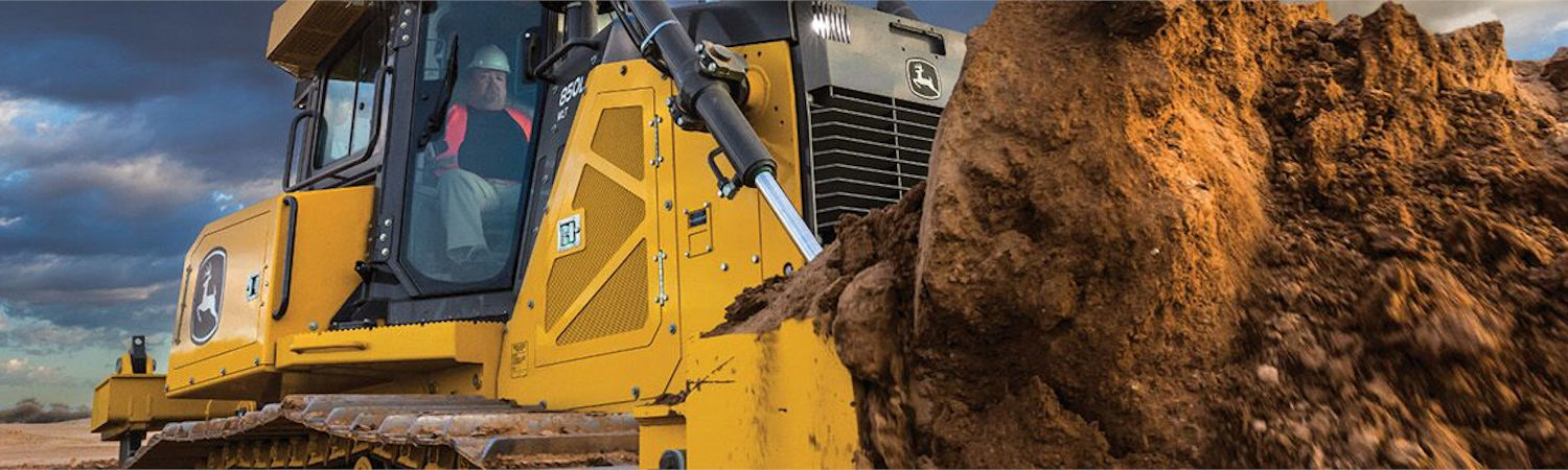 Worker in a crawler dozer moving dirt on a construction site